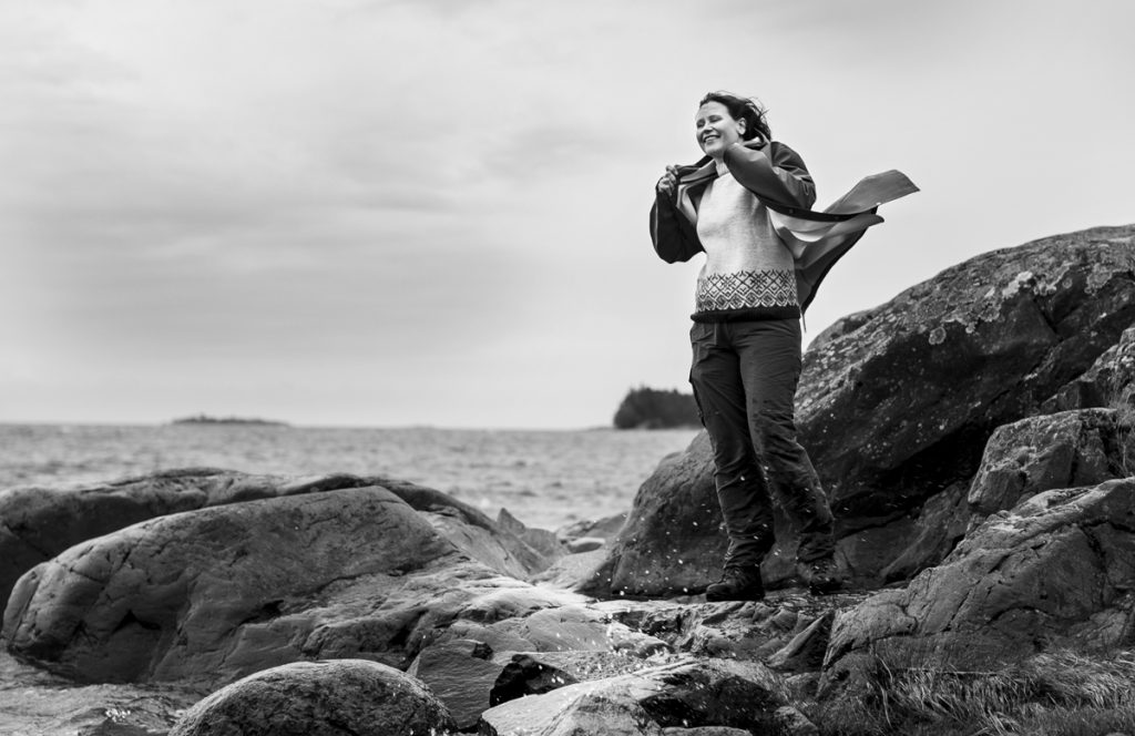 Pauliina Penttilä seisoo meren rannalla tuulessa