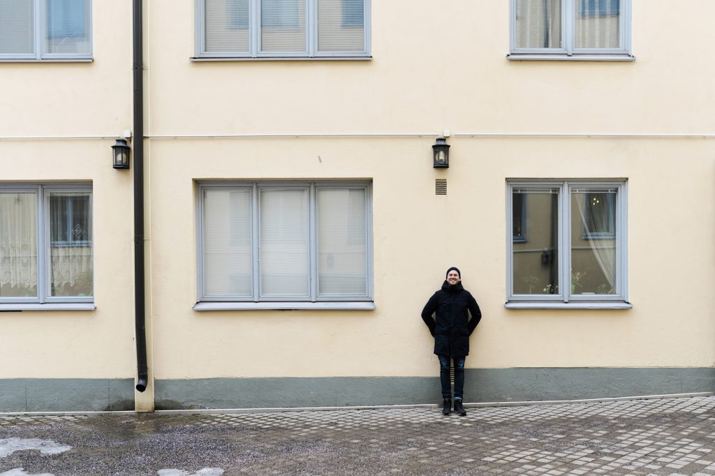 Tommy Lindgren nojaa kerrostalon seinää vasten urbaanissa miljöössä
