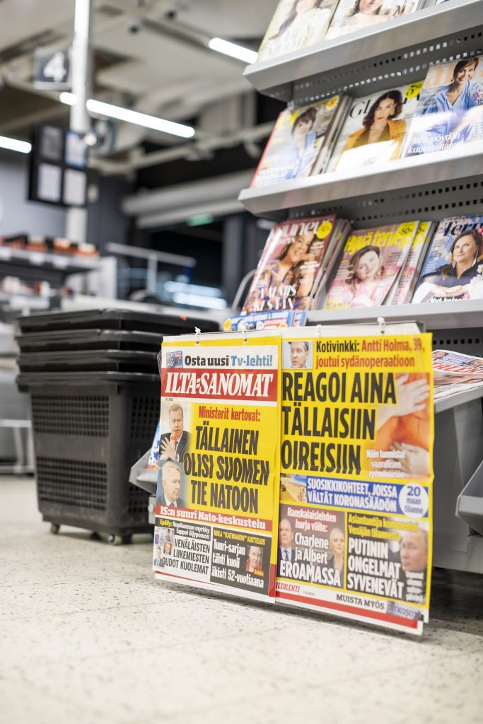 Ilta-Sanomien ja Iltalehden suurella kirjaisimella painetut lööppiotsikot kiinnittävät huomion kassajonossa.